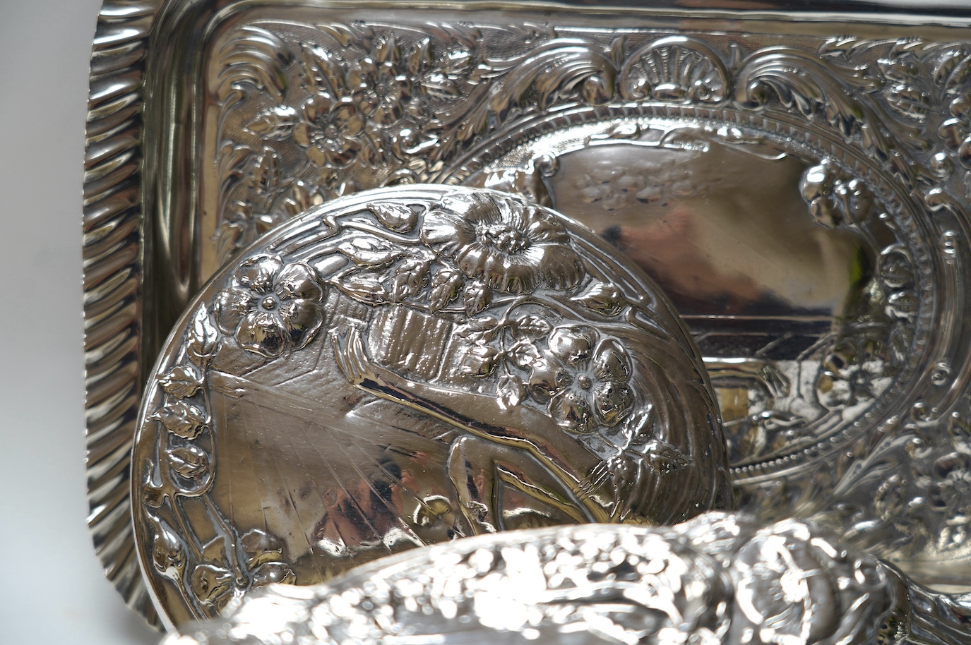 An Edwardian Art Nouveau four piece dressing table set including a tray, Birmingham, 1904, 30.3cm and a similar silver mounted shoe horn. Condition - poor to fair